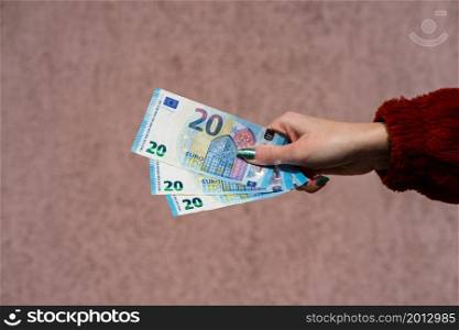 Hand holding showing euro money and giving or receiving money like tips, salary. 20 EURO banknotes EUR currency isolated. Concept of rich business people, saving or spending money.