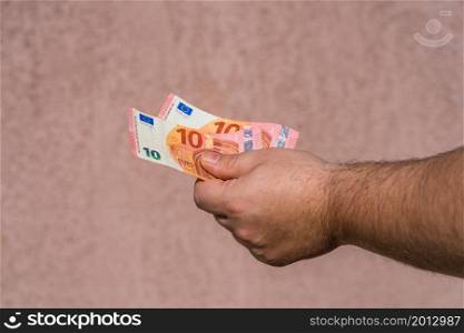 Hand holding showing euro money and giving or receiving money like tips, salary. 10 EURO banknotes EUR currency isolated. Concept of rich business people, saving or spending money.