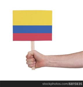 Hand holding small card, isolated on white - Flag of Colombia