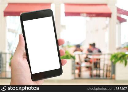 Hand holding smart phone over blur restaurant background, mock up, template, restaurant reservation, food online, food delivery concept