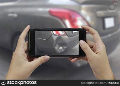 Hand holding smart phone take a photo at The scene of a car crash, car accident for insurance.