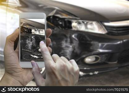 Hand holding smart phone take a photo at The scene of a car crash and accident, car accident for insurance.