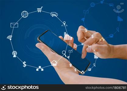 Hand holding smart phone with blurred social media and shopping icons on blue color background.