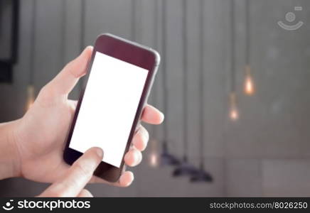 Hand holding smart phone with light blurred background, stock photo