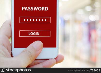 Hand holding smart phone with password login on screen over blur background, cyber security concept