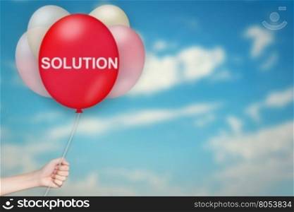 Hand Holding solution Balloon with sky blurred background