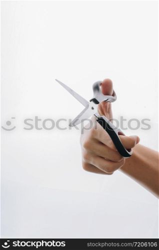 Hand holding steel scissors on a white backgruond