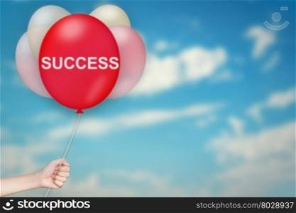 Hand Holding success Balloon with sky blurred background