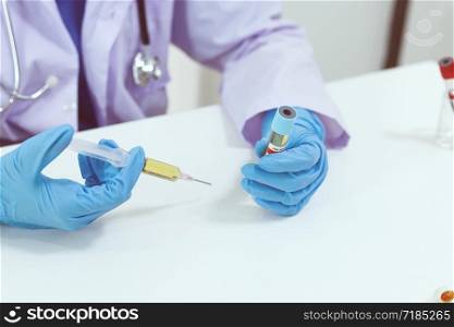 Hand holding syringe and vaccine treatment from Coronavirus covid-19 infection medicine and drug concept