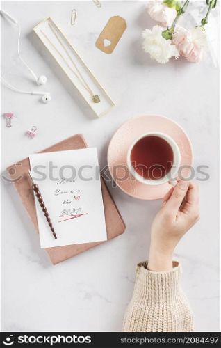 hand holding tea beverage flat lay