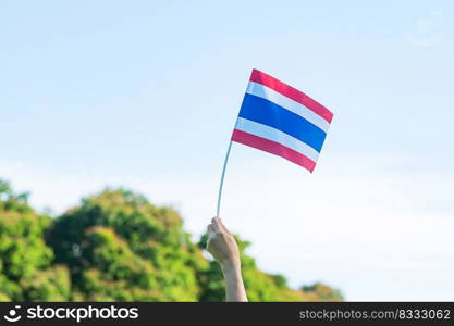 hand holding Thailand flag on nature background. Thai Nation Day and father day concepts