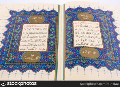 Hand holding The Holy Quran on a white background. The Holy Quran