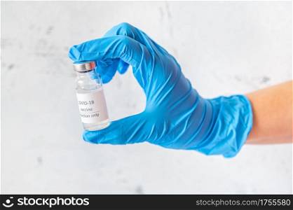 Hand holding the tube of Coronavirus vaccine