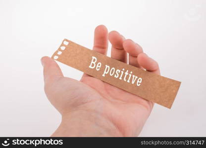 Hand holding torn notepaper with be Positive thinking concept label