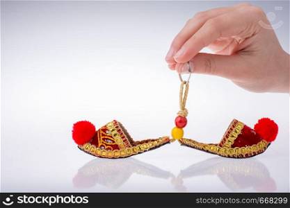 Hand holding traditional Turkish handmade shoes on white background