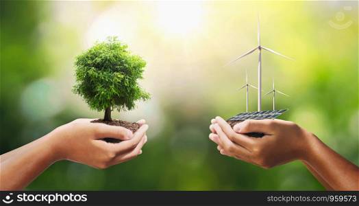 hand holding tree with turbine and solar panel. concept eco energy and clean power
