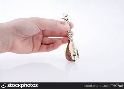 Hand holding turkish musical instrument saz on a white background