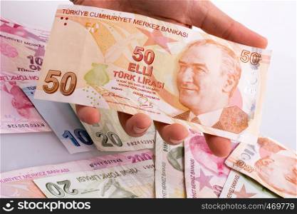 Hand holding Turksh Lira banknote on white background