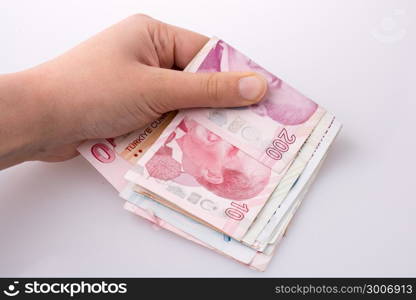 Hand holding Turksh Lira banknotes on white background