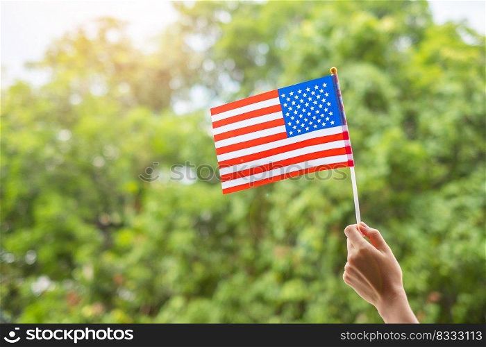 hand holding United States of America flag on green background. USA holiday of Veterans, Memorial, Independence   Fourth of July  and Labor Day concept