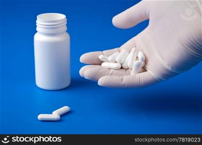 hand holding white pills. hand holding white pills