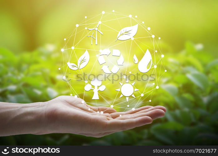 Hand holding with environment Icons over the Network connection on nature background, Technology ecology concept.