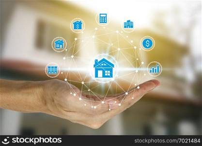 Hand holding with property investment icons over the Network connection on property background, Property investment concept.