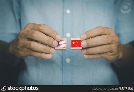hand holding wood block concept business import export United States of America and China,US and China flag trading punches for the concept  Trade War.