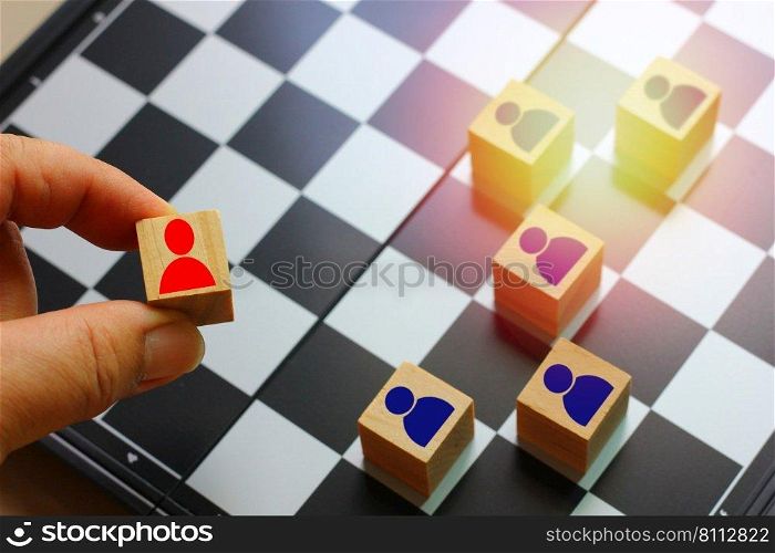 hand holding wood block with red people icon in hand plan to put on chess board  , idea human  resource