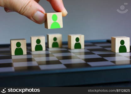 hand holding wood block with red people icon plan put on chess board , idea working concept