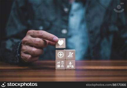 hand holding wood cube heart healthcare sign for world heart day concept