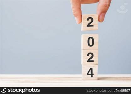 hand holding wooden cube block with 2024 text on table background. Resolution, plan, review, goal, start and New Year holiday concepts