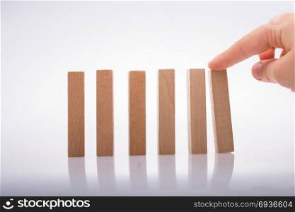 Hand holding wooden domino on a white background