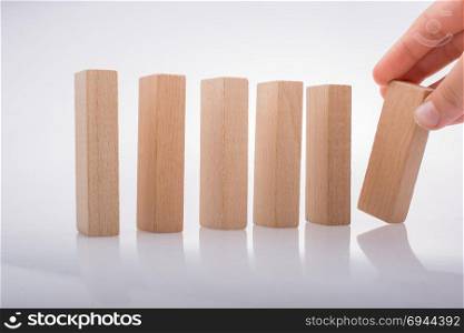 Hand holding wooden domino on a white background