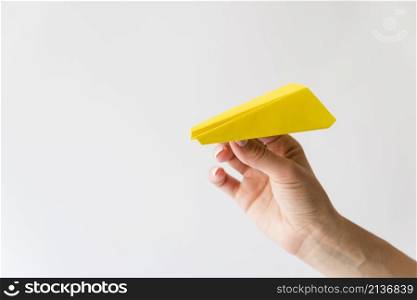 hand holding yellow paper plane