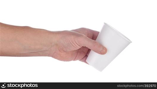 Hand holds out a white plastic cup. Isolated on white background.. Hand holds out white plastic cup