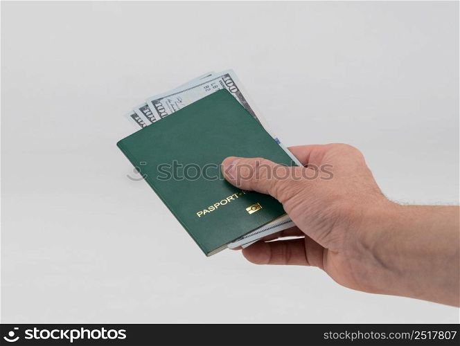 Hand holds out green passport with usa dollars. Concept - briber and corruption. green passport on a white background