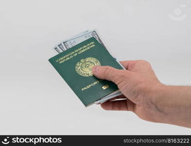 Hand holds out Uzbekistan passport with usa dollars. Concept - briber and corruption. passport of Uzbekistan, on white background