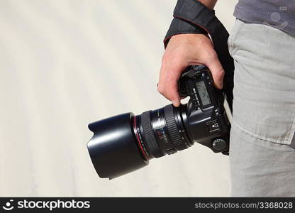 hand holds photo camera and sand