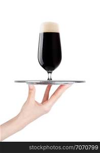 Hand holds tray with cold stout dark beer with dew on white background with reflection
