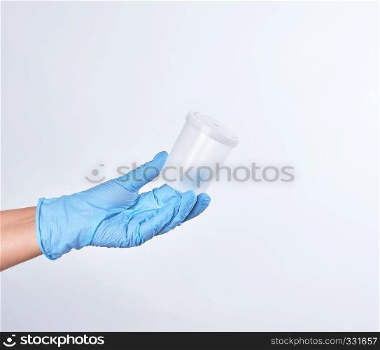 hand in a blue sterile glove holds a empty plastic container for collecting analyzes, white background