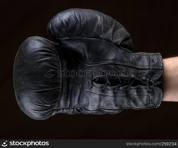 hand in black leather boxing glove , close up