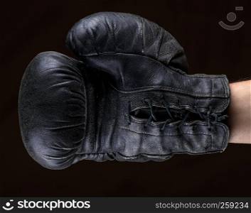 hand in black leather boxing glove , close up