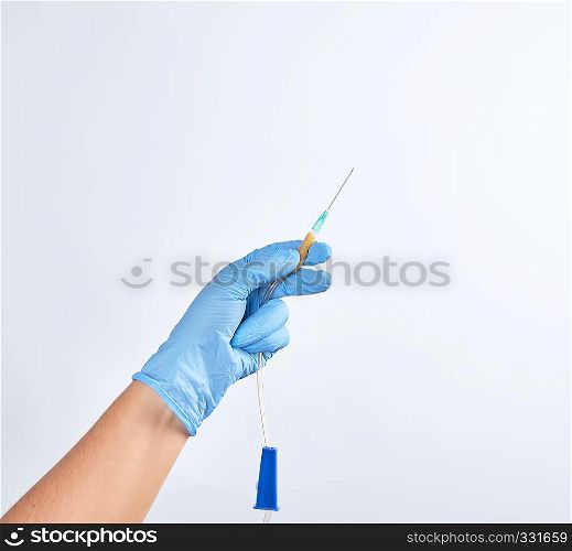 hand in blue sterile glove holds plastic dropper system on white background, copy space