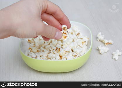 Hand in bowl of popcorn