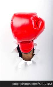 Hand in boxing glove through paper hole