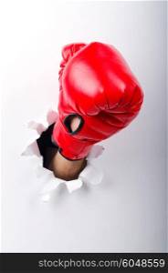 Hand in boxing glove through paper hole