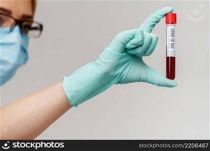 hand in latex glove holding blood in test tube close up.. hand in latex glove holding blood in test tube close up
