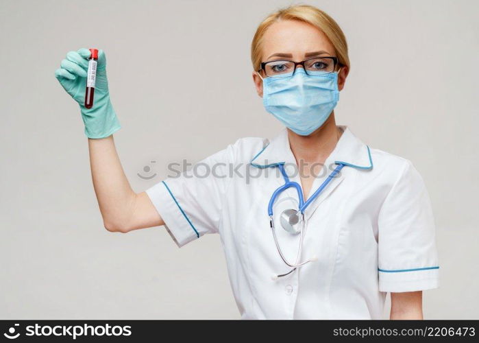 hand in latex glove holding blood in test tube close up.. hand in latex glove holding blood in test tube close up