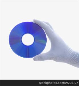 Hand in latex glove holding compact disc against white background.